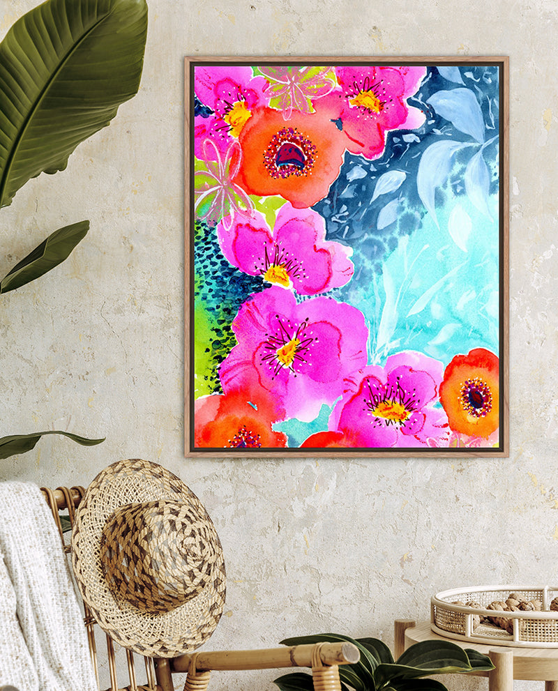 A vibrant floral artwork titled 'Joyful Garden' displayed on a wall above a tropical hat collection, with pink and blue flowers and leaves on a white background.