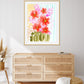A framed painting titled 'Flowering Hearts' with pink and coral flowers against a light background, displayed above a wooden cabinet.