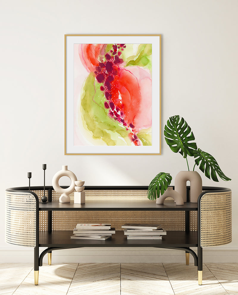 A framed abstract painting with predominantly red and green colors, displayed above a console table in a room with various decorative items.