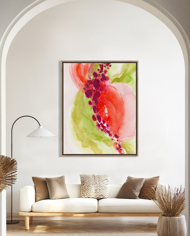A abstract art print featuring swirling hues of rich crimson, soft limes, and delicate blush with white specks, displayed on a wall above a white sofa in a well-lit room.