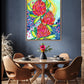 A vibrant abstract floral print with bold splashes of pink and red, and hints of yellow and blue, displayed on a wall above a dining table and chairs.