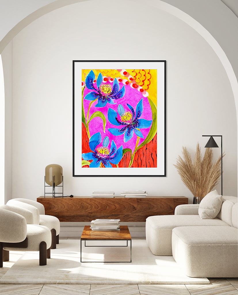 A colorful abstract floral artwork titled 'Summer Dreams' hanging on a wall in a bright living room setting, featuring vibrant red, blue, and pink hues with a dance-like composition.